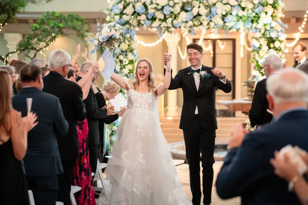 Mackenzie and Branko celebrating beneath the floral arch at The Addison
