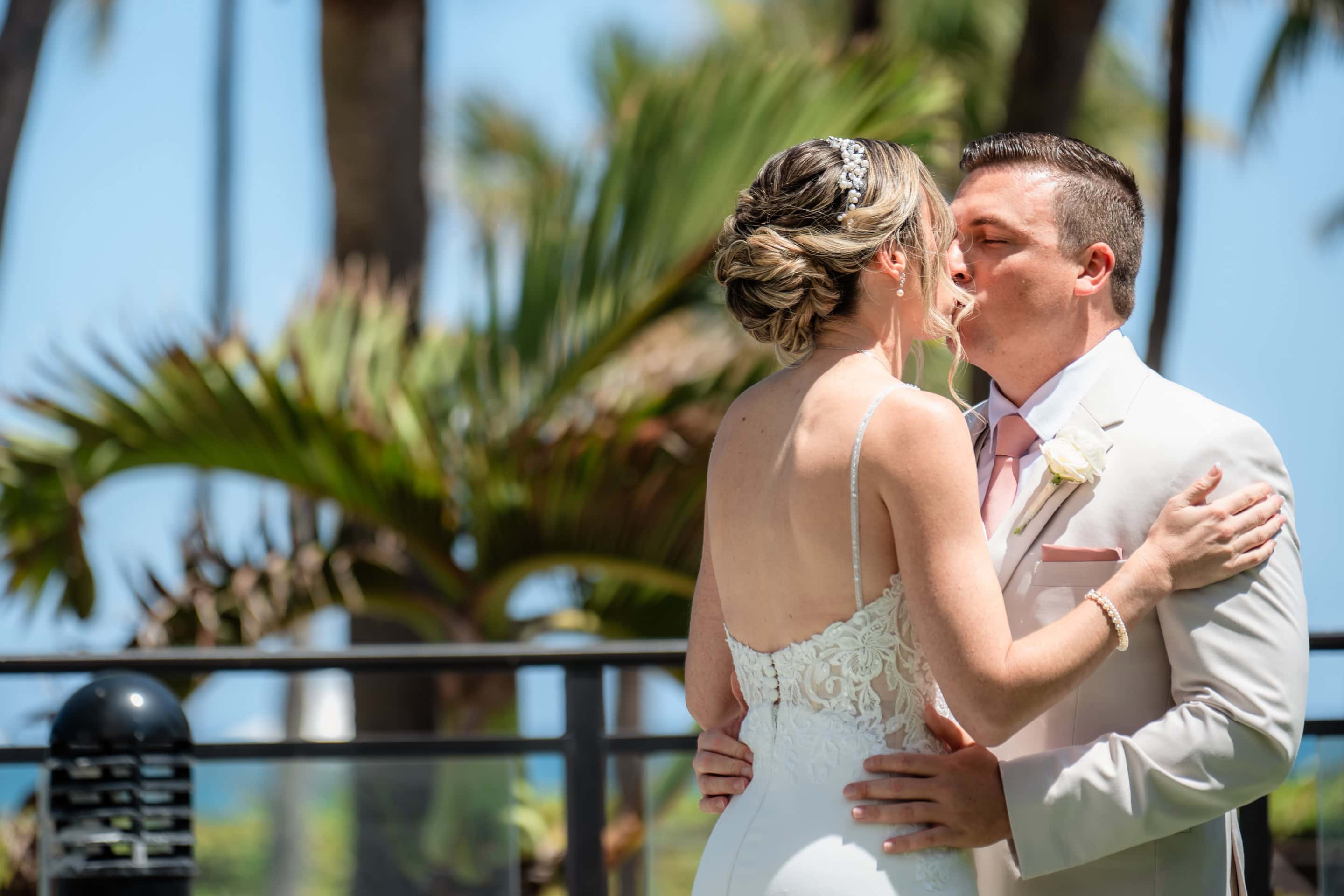 Jenna and Alex sharing a wedding-day kiss beside the palms at Marriott Harbor Beach