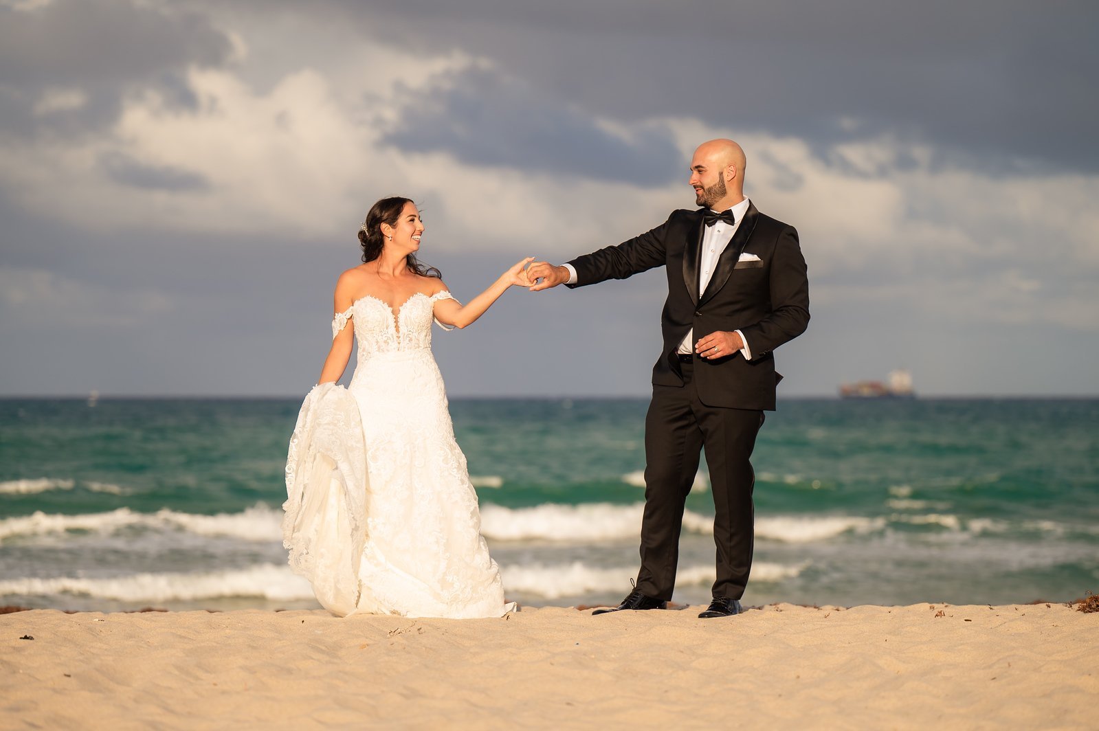 Arielle and David holding hands on Fort Lauderdale Beach on their wedding day