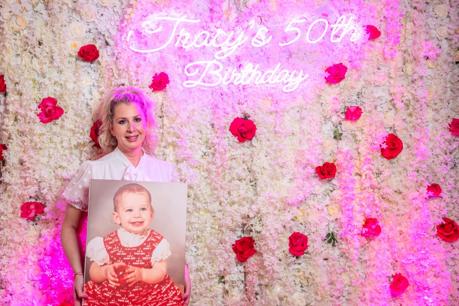 Tracy celebrating her 50th birthday in front of a floral wall in South Florida
